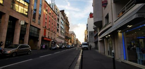 a city street with cars parked on the side of the road at Le Coffice Auberge de Jeunesse in Paris