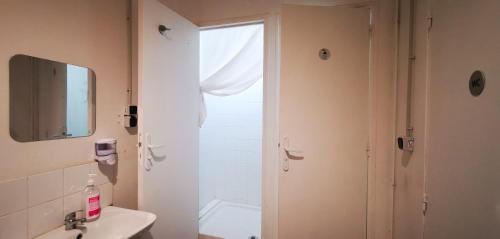 a bathroom with a sink and a toilet and a mirror at Le Coffice Auberge de Jeunesse in Paris