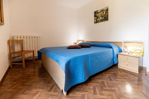 1 dormitorio con 1 cama azul y suelo de madera en Residence Bonetti, en Rabbi