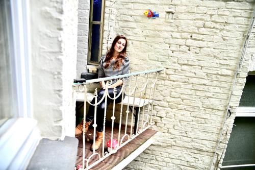 a woman sitting on a balcony of a building at Blue Edition Cologne in Cologne