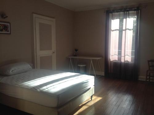 - une chambre avec un lit, une fenêtre et une table dans l'établissement Appartement en centre ville, à Nevers