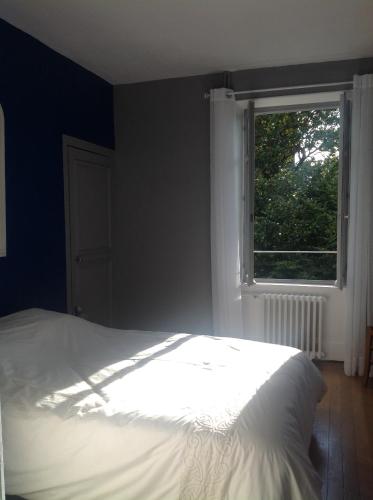- une chambre avec un lit blanc et une fenêtre dans l'établissement Appartement en centre ville, à Nevers