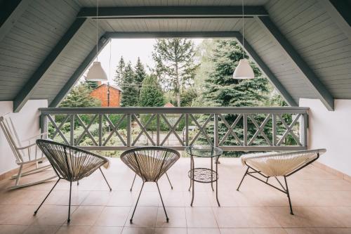a patio with three chairs and a table on a balcony at Csónakos ház / The boat house in Badacsonyörs