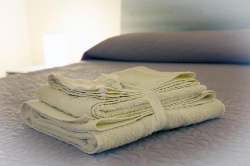 a pile of towels sitting on top of a bed at La casa del ciliegio - appartamento a Caserta in Caserta