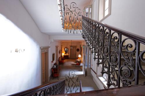 un couloir avec un escalier doté d'une balustrade en fer forgé dans l'établissement Le Grand Hotel, à Sète