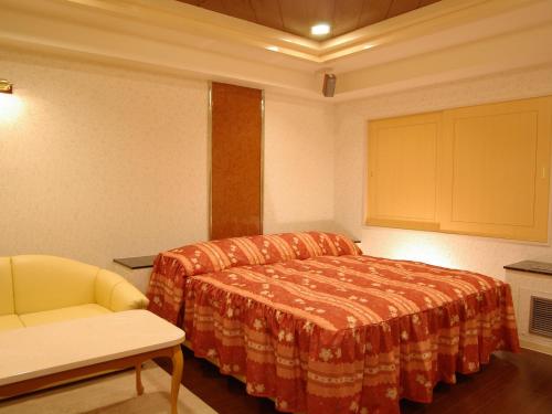 a bedroom with a bed and a chair in a room at Hotel Fine Olive Sakai in Sakai