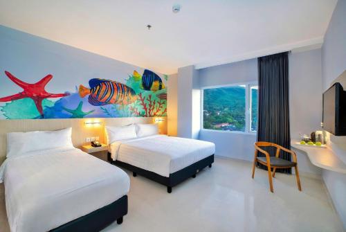 a hotel room with two beds and a painting on the wall at favehotel Bitung in Bitung