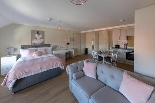 a bedroom with a bed and a couch and a kitchen at Apartment 9, Isabella House, Aparthotel, By RentMyHouse in Hereford