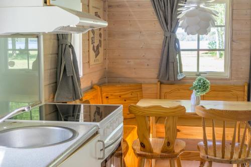 eine Küche mit einem Waschbecken und einem Tisch mit Stühlen in der Unterkunft Danhostel Skanderborg in Skanderborg
