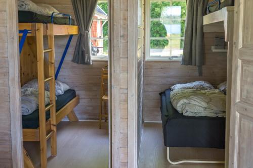 two bunk beds in a tiny house with a window at Danhostel Skanderborg in Skanderborg