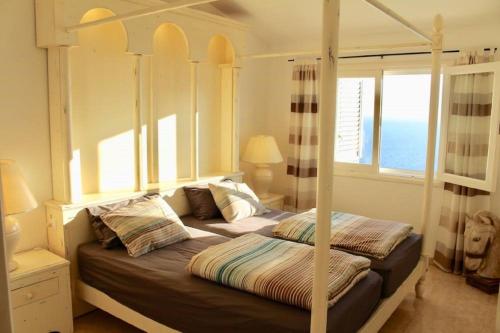 a bedroom with two beds and a window with the ocean at Jandia Mar in Morro del Jable
