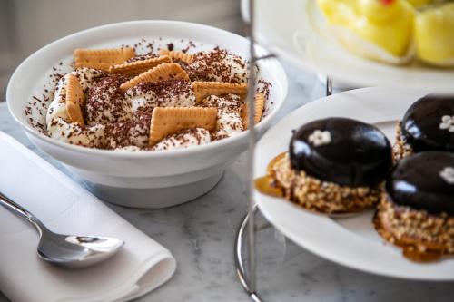 a bowl of dessert on a table with a plate of pastries at Heritage Hotel FERMAI MGallery Split in Split