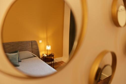 reflejo de una cama en un espejo en Le Grand Hotel, en Sète