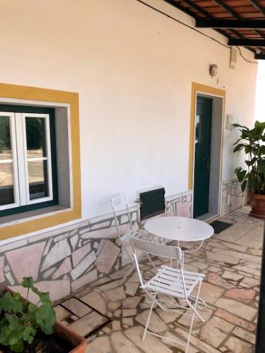 a patio with a table and chairs and a window at Casas da Saibreira - nº9 in Elvas