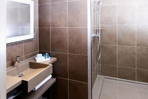 a bathroom with a sink and a shower at Novotel Roissy Saint Witz in Saint-Witz