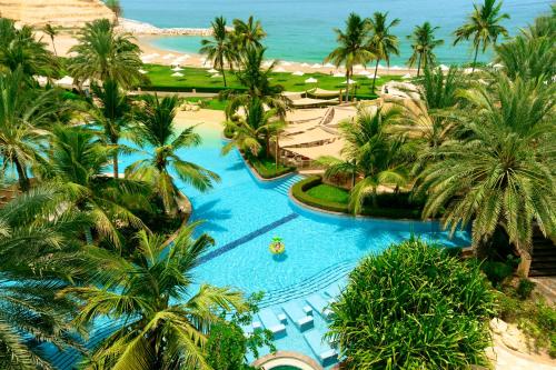 - une vue aérienne sur la piscine du complexe bordée de palmiers dans l'établissement Shangri-La Barr Al Jissah, Muscat, à Mascate