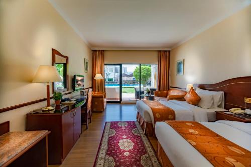 Postel nebo postele na pokoji v ubytování Golden Tulip Nizwa Hotel