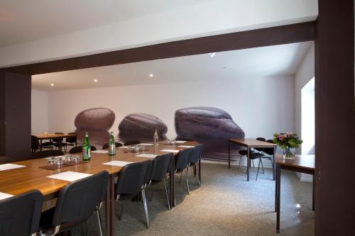 a dining room with tables and chairs withurns on the wall at Le Grand Hotel in Sète