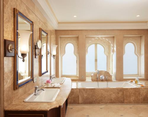 a bathroom with two sinks and a bath tub at Taj Fateh Prakash Palace Udaipur in Udaipur