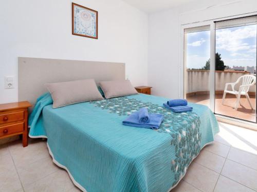 een slaapkamer met een bed met blauwe handdoeken bij Villa Villa Cala Llenya by Interhome in Les tres Cales