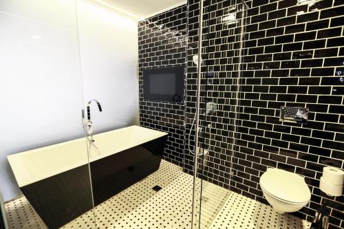 a bathroom with a toilet and a glass shower at Garden Hotel Boutique & Events in Haifa