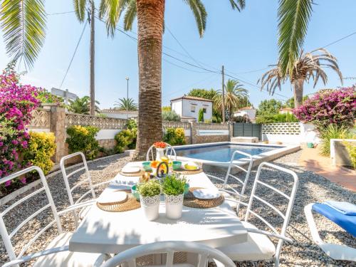 a table and chairs in front of a swimming pool at Holiday Home D'Ibis by Interhome in Empuriabrava