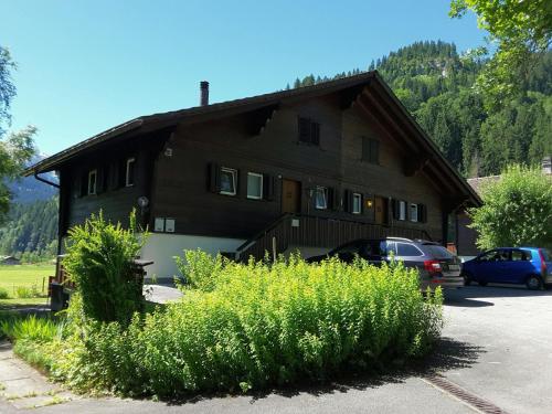 a house with cars parked in front of it at Apartment Chalet Claudia by Interhome in Lenk