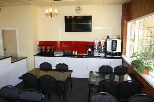 a room with a table and chairs and a kitchen at Nhill Oasis Motel in Nhill