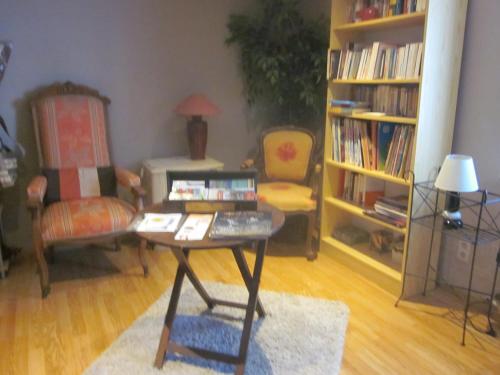 a living room with a table and a chair at Chambres au calme en Ardenne in Fauvillers