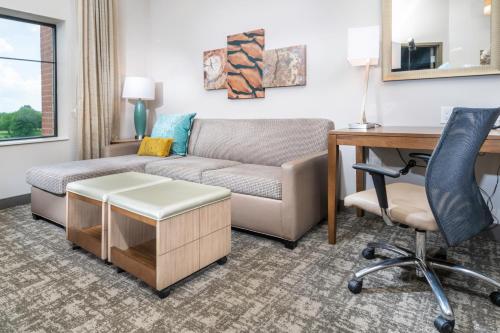 a living room with a couch and a desk at Staybridge Suites Florence - Cincinnati South by IHG in Florence