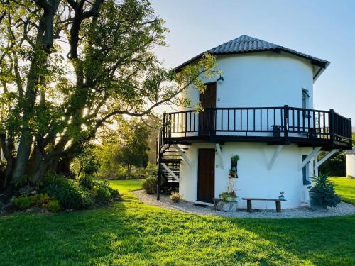 a white house with a balcony and a yard at Bella Manga Country Escape in Plettenberg Bay