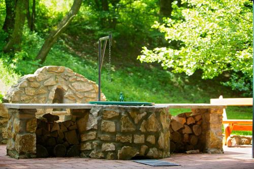 a stone fountain with a shower in a park at Bakony Resort - a Felnőttbarát Hotel - Szarvaskút Vendégpark in Zirc