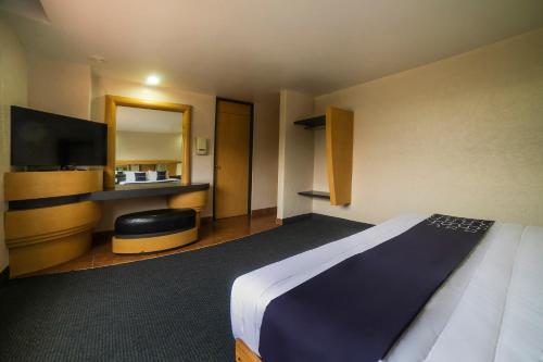 a hotel room with a bed and a flat screen tv at Capital O Autoparador Del Valle,Centro Industrial Tlalnepantla in Mexico City