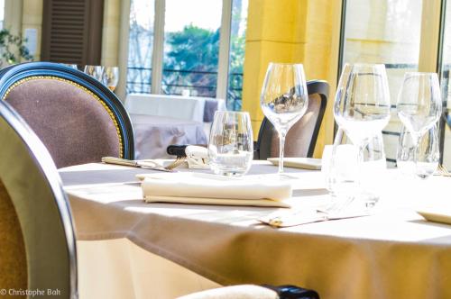 a table with wine glasses and napkins on it at Les Jardins d'Epicure in Bray-et-Lû