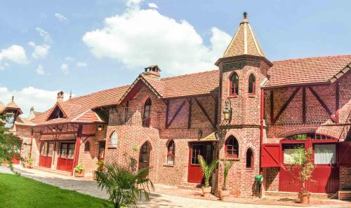 a large brick building with a tower on top at Les Jardins d'Epicure in Bray-et-Lû