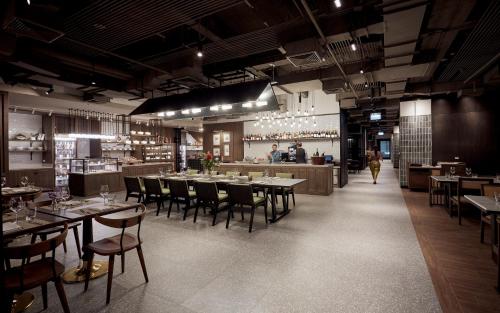 a restaurant with tables and chairs and a bar at Montien Hotel Surawong Bangkok in Bangkok