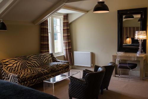 a living room with a couch and a table and chairs at Milsoms Kesgrave Hall in Ipswich