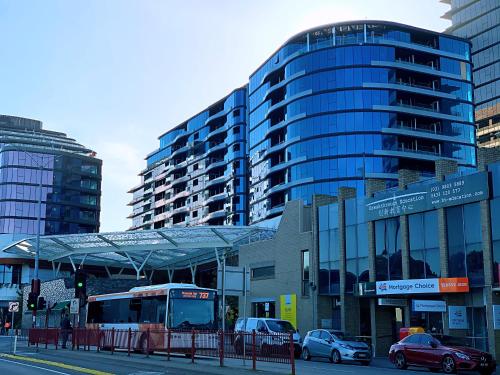 a bus stop with cars parked in front of a building at Skygarden Luxury Condo in Glen Waverley