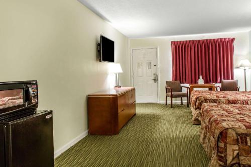 a hotel room with two beds and a television at Rodeway Inn in Groton