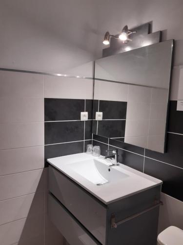 La salle de bains est pourvue d'un lavabo et d'un miroir. dans l'établissement Logis Hotel Le Relais du Serre, à Dieulefit