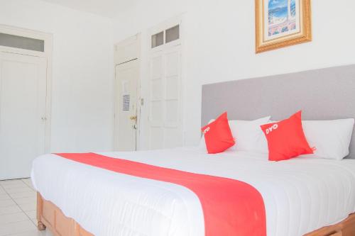 a bedroom with a large white bed with red pillows at Hotel Imperial in Aguascalientes