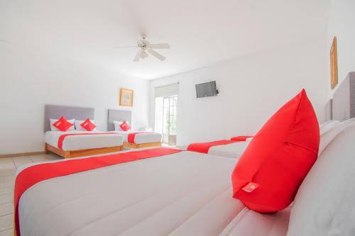 a bedroom with two beds with red pillows at Hotel Imperial in Aguascalientes