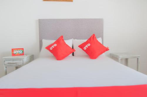 a bedroom with red pillows on a white bed at Hotel Imperial in Aguascalientes