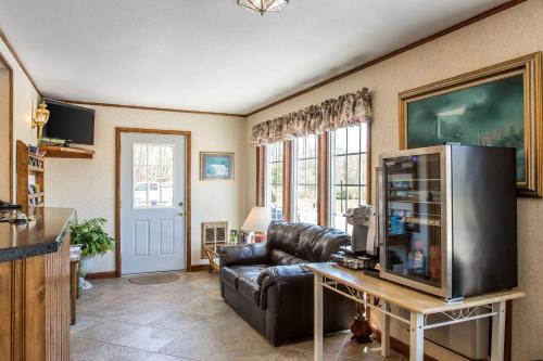 a living room with a leather couch and a television at Rodeway Inn Waterford - New London in Waterford