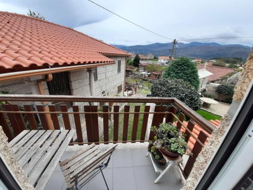 a balcony with a bench and plants on it at Casa de Bairros in Soajo