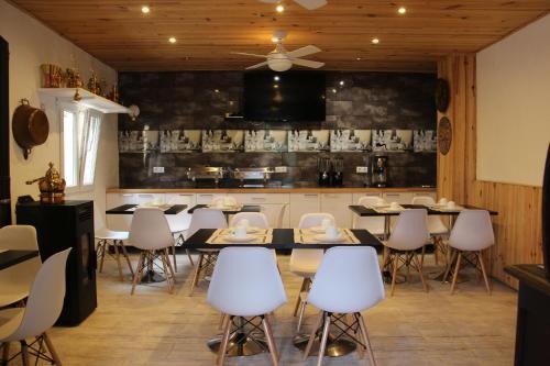 a dining room with white chairs and tables and a kitchen at Casa Robion in Godelleta