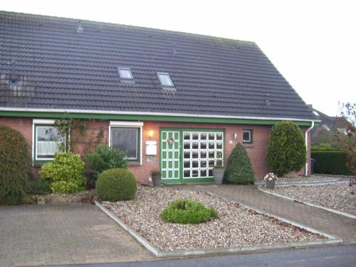 dom z czerwonej cegły z zielonymi drzwiami w obiekcie Achterkoje w mieście Heiligenhafen