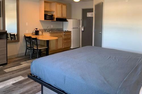 a bedroom with a bed and a kitchen with a table at Suburban Studios near Panama City Beach in Panama City
