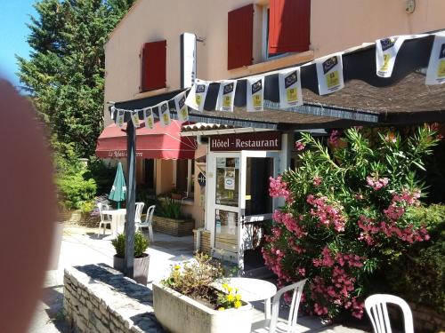 a building with tables and chairs in front of it at Logis Hotel Le Relais du Serre in Dieulefit