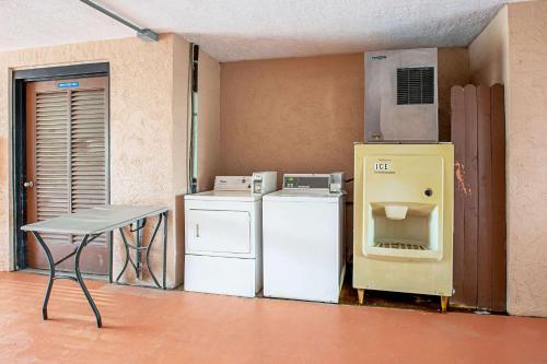 a kitchen with a stove and a refrigerator and a table at Quality Inn & Suites Live Oak I-10 Exit 283 in Live Oak